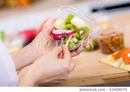 Hands holding Fresh fruits salad in box Hands holding Fresh fruits salad in box 63409070