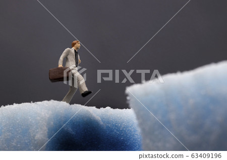 Businessman about to fall into hole 63409196