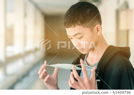 A male Asian high school student is wearing the mask in the midst of COVID-19 epidemic  63409796