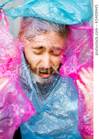Conceptual portrait of a man covered with plastic bags Conceptual portrait of a man covered with plastic bags 63409945