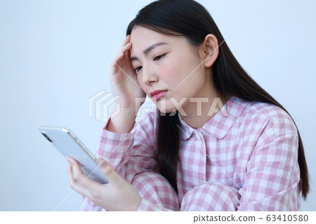 一個穿著睡衣的智能手機的女人的形象 63410580