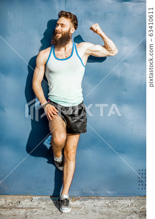 Portrait of an old-fashioned athlete on the green background 63410611