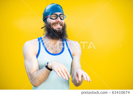Portrait of a weird swimmer on the yellow background 63410674
