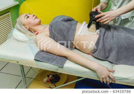 Woman getting cryolipolysis fat treatment in Woman getting cryolipolysis fat treatment in 63410786