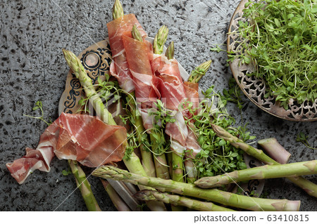 Asparagus wrapped in prosciutto with cress salad . Asparagus wrapped in prosciutto with cress salad . 63410815