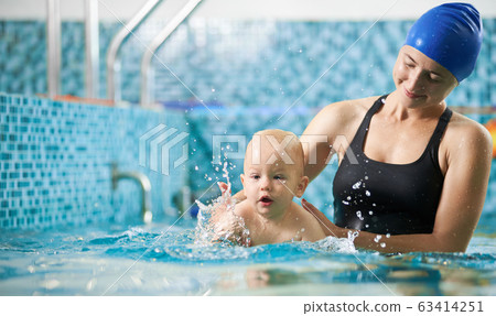 Mother with baby boy in swimming pool training Mother with baby boy in swimming pool training 63414251
