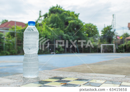 Cold drinking water in bottles on the table In the soccer field. 63415658