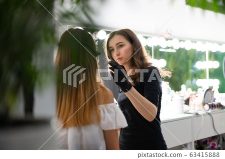 Young beautician caucasian girl holds model Young beautician caucasian girl holds model 63415888