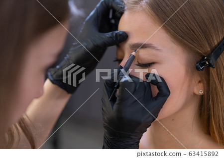 Young beautician caucasian girl holds model Young beautician caucasian girl holds model 63415892