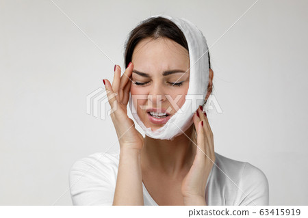 young sad woman suffering from tooth pain 63415919