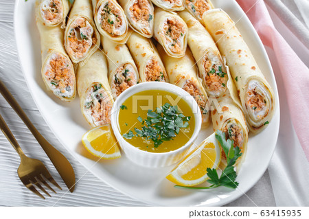 Pancakes stuffed with soft cream cheese and salmon 63415935
