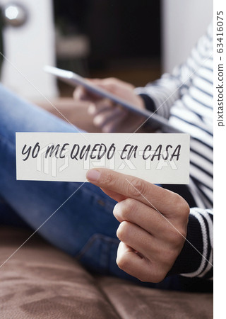 man showing the message I stay at home in spanish. man showing the message I stay at home in spanish. 63416075