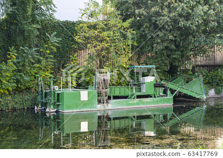 An aquatic weed harvester on a lake. An aquatic weed harvester on a lake. 63417769
