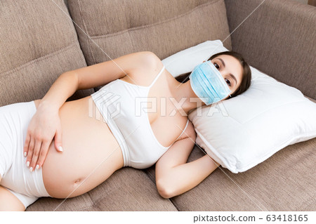 Pregnant woman in protective medical mask Pregnant woman in protective medical mask 63418165