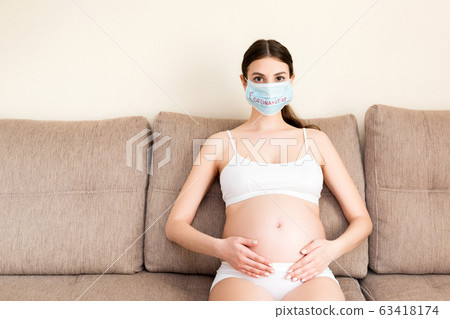 Pregnant woman in protective medical mask Pregnant woman in protective medical mask 63418174