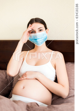 Pregnant woman in protective medical mask Pregnant woman in protective medical mask 63418186