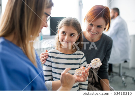 A small girl, mother and dentist in surgery, dental checkup. 63418310
