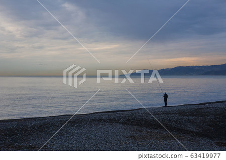 Fisherman at dawn by the sea 63419977
