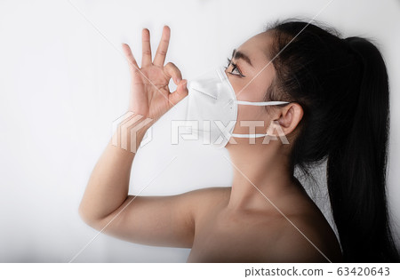 Woman putting on a respirator N95 mask to protect from airborne respiratory diseases as the flu 63420643