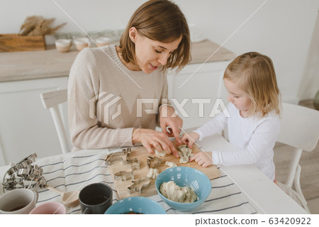 A young mother spends time with her little daughter at home. 63420922