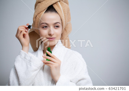 Cute woman makes makeup to the face in the bathroom Cute woman makes makeup to the face in the bathroom 63421701