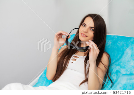 Pretty young woman receives laser hair removal for legs at beauty salon 63421716