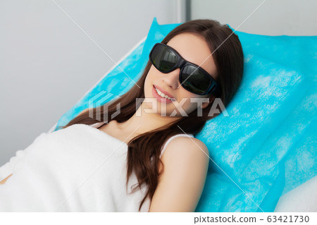 Pretty young woman receives laser hair removal for legs at beauty salon Pretty young woman receives laser hair removal for legs at beauty salon 63421730
