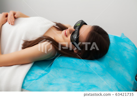Pretty young woman receives laser hair removal for legs at beauty salon Pretty young woman receives laser hair removal for legs at beauty salon 63421735