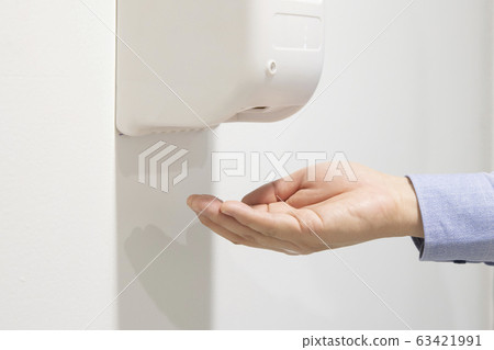 Hands Using Automatic Alcohol Dispenser to Clean Hands Using Automatic Alcohol Dispenser to Clean 63421991