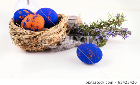 A nest with easter eggs and rosemary close up on a white background A nest with easter eggs and rosemary close up on a white background 63423420
