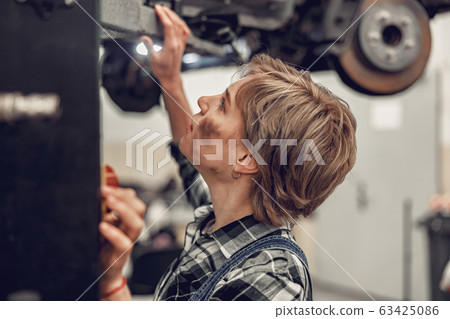 Caucasian female worker using a hydraulic jack 63425086