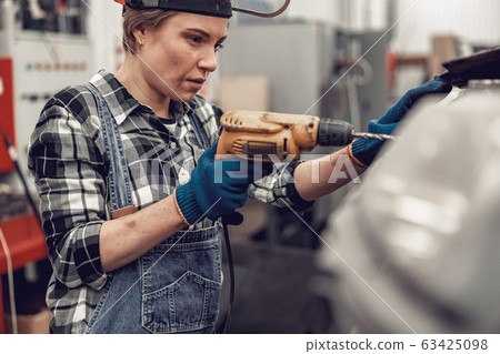 Focused young auto technician repairing a car Focused young auto technician repairing a car 63425098
