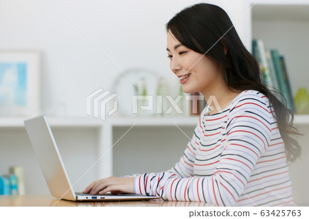 年輕女子客廳電腦 63425763