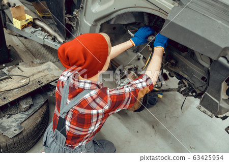 Young car mechanic inspecting the brake system Young car mechanic inspecting the brake system 63425954