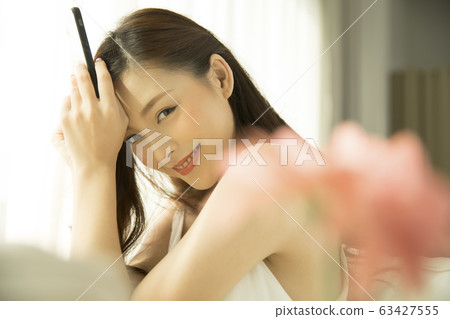 Young woman with smartphone relaxing Young woman with smartphone relaxing 63427555