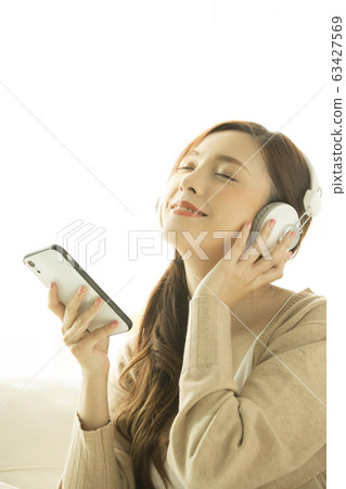 一個女人聽音樂和放鬆 一個女人聽音樂和放鬆 63427569