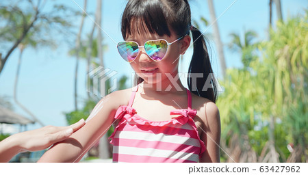 apply sunscreen on girl arm apply sunscreen on girl arm 63427962
