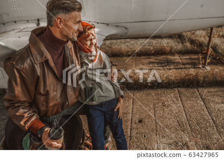 Happy man with coffee hugging his son Happy man with coffee hugging his son 63427965