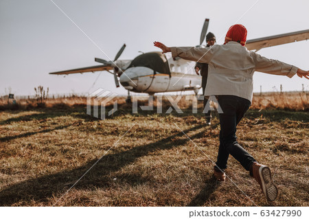 Little kid having fun with his father near plane 63427990