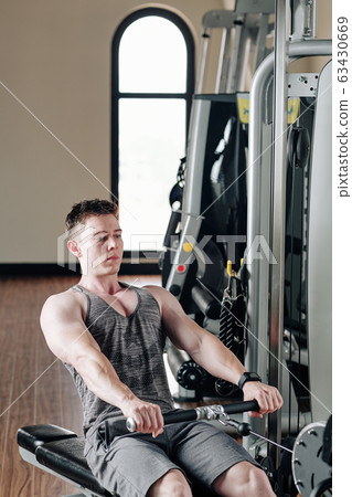 Bodybuilder concentrated on doing exercise Bodybuilder concentrated on doing exercise 63430669