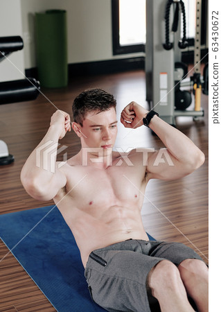 Fit man doing sit-ups 63430672