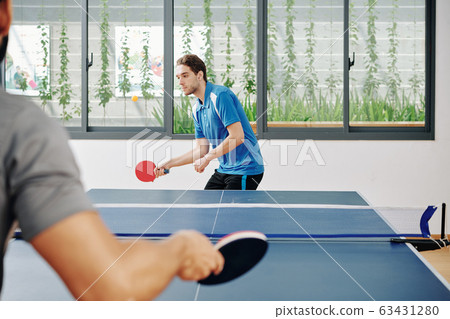 Sportsman playing ping pong with friend 63431280