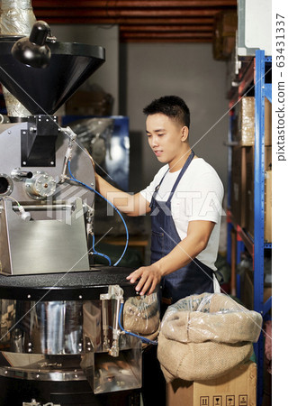 Young man roasting coffee 63431337