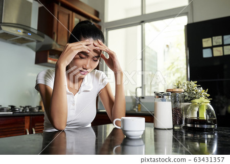 Sleepy young woman in kitchen 63431357