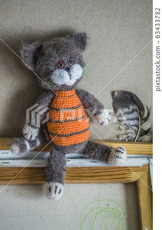 Knitted striped handmade crafted cat. Knitted striped handmade crafted cat. 63433782
