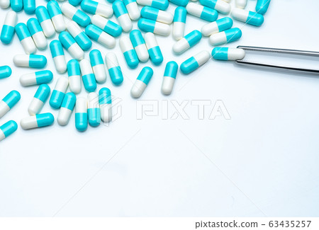 Forceps pick white-blue capsule pills. Antibiotics 63435257