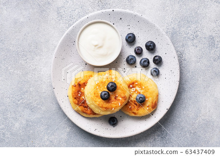 Fritters of cottage cheese with blueberries. 63437409