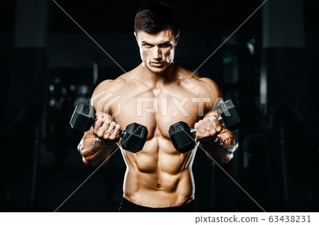 Bodybuilder strong man pumping up biceps muscles 63438231