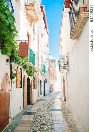 The narrow streets of the island with blue balconies, stairs and flowers. The narrow streets of the island with blue balconies, stairs and flowers. 63439225