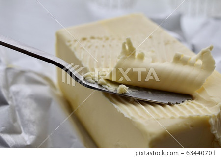 Commercial butter shaved with a serrated butter knife 63440701